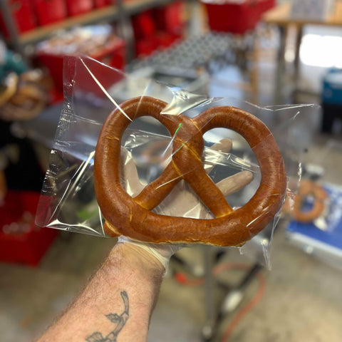 Philip holding bagged individual pretzel after arrival of new flow-wrapper machine
